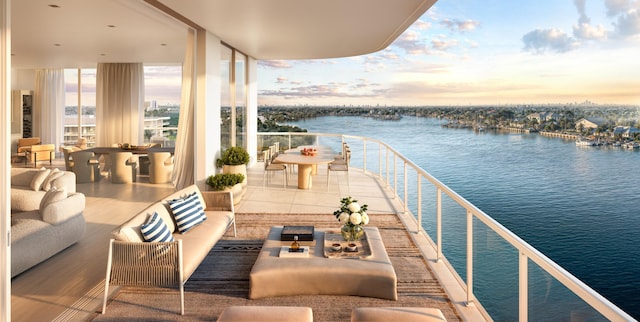 balcony at dusk with an outdoor living space and a water view