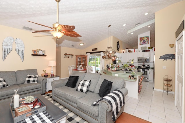 tiled living room with a textured ceiling, ceiling fan, and lofted ceiling