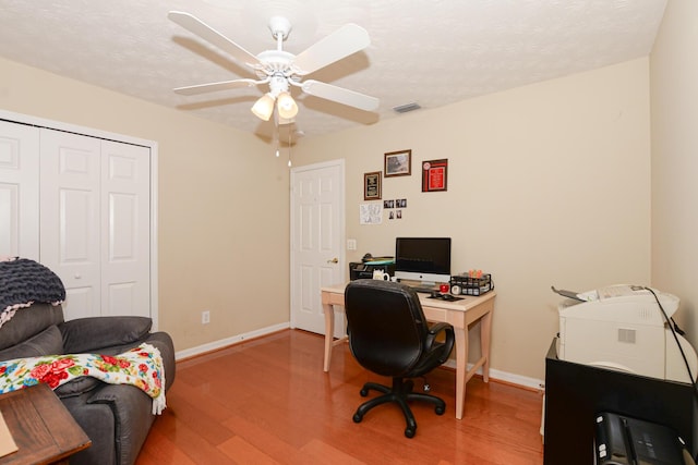 office featuring hardwood / wood-style flooring, ceiling fan, and a textured ceiling