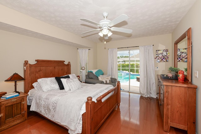 bedroom featuring access to exterior, a textured ceiling, hardwood / wood-style flooring, and ceiling fan