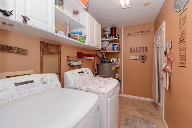 clothes washing area with water heater, cabinets, a textured ceiling, and independent washer and dryer