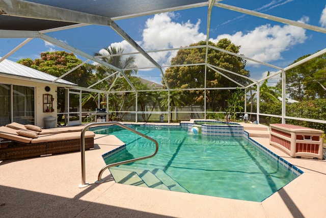 view of pool with an in ground hot tub, glass enclosure, and a patio area