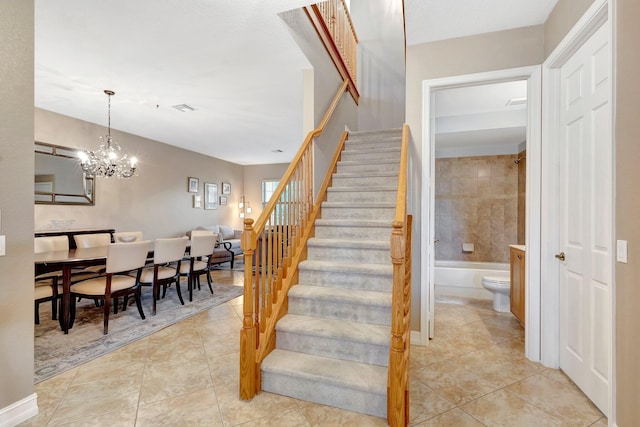 staircase featuring a notable chandelier and tile patterned floors