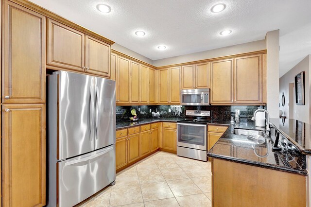 kitchen featuring a breakfast bar, kitchen peninsula, decorative backsplash, light tile patterned flooring, and appliances with stainless steel finishes