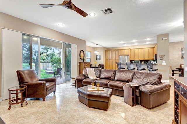 tiled living room with ceiling fan