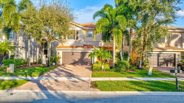 11606 Ponywalk Trl, Boynton Beach, FL 33473 - mediterranean / spanish home featuring an attached garage, decorative driveway, and stucco siding