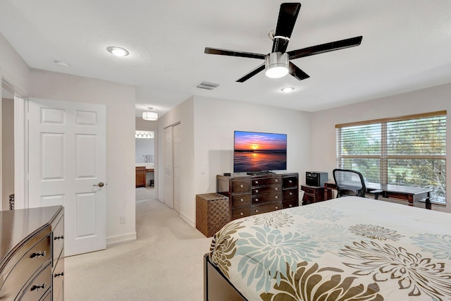 bedroom with ceiling fan, light carpet, and a closet