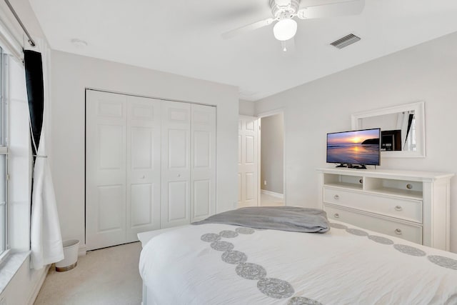 bedroom featuring ceiling fan, a closet, and light colored carpet