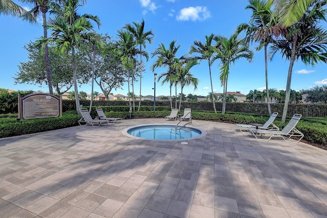 view of swimming pool featuring a patio area and a hot tub