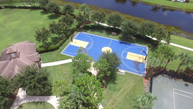 view of sport court featuring a water view and a lawn