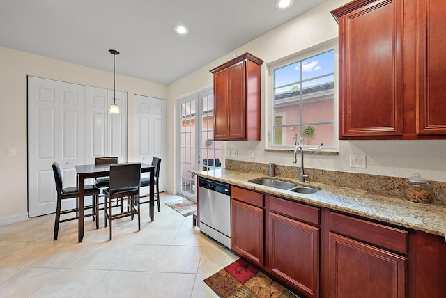 kitchen featuring pendant lighting, stainless steel dishwasher, sink, light stone countertops, and light tile patterned floors