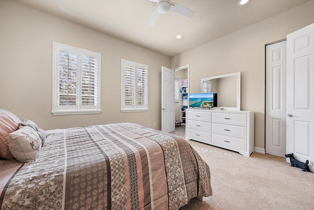 bedroom featuring ceiling fan, light carpet, and a closet