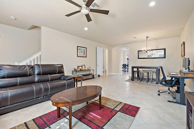 tiled living room with ceiling fan with notable chandelier