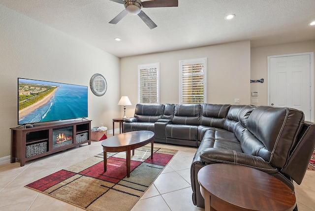 tiled living room featuring ceiling fan and a textured ceiling