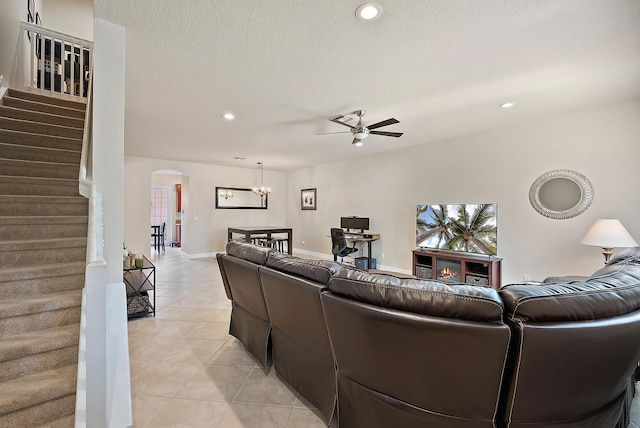 tiled living room with ceiling fan and a textured ceiling