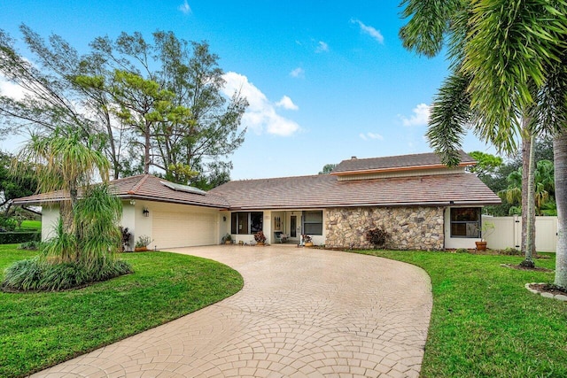 ranch-style home with a garage and a front yard