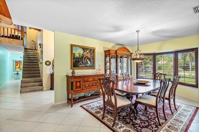 dining area with a textured ceiling and light tile patterned floors