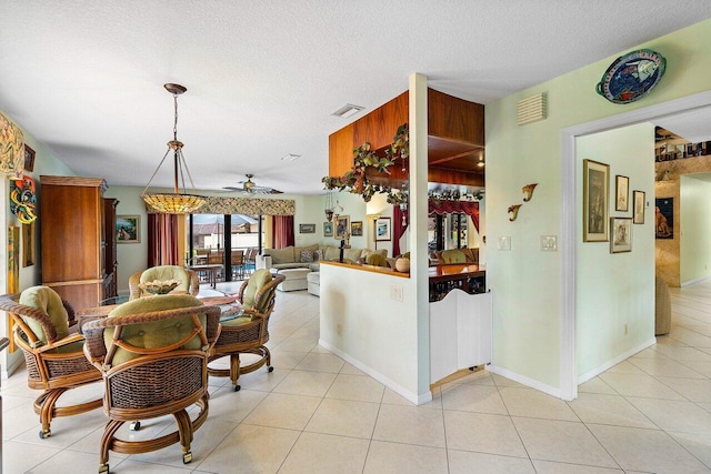 dining area featuring ceiling fan, light tile patterned floors, and a textured ceiling