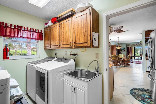 laundry area featuring cabinets, sink, independent washer and dryer, and a healthy amount of sunlight