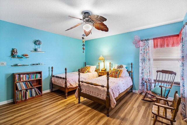 bedroom with ceiling fan, a textured ceiling, and hardwood / wood-style flooring