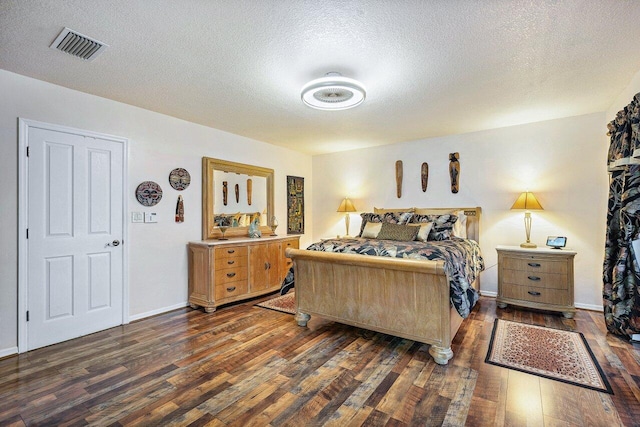 bedroom with dark wood-type flooring and a textured ceiling