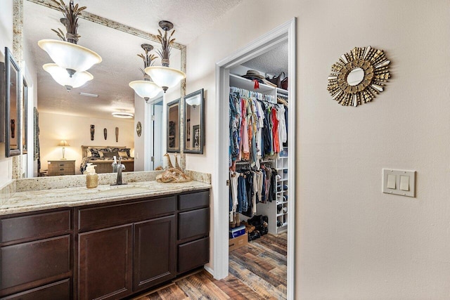 bathroom featuring a textured ceiling, hardwood / wood-style floors, and vanity