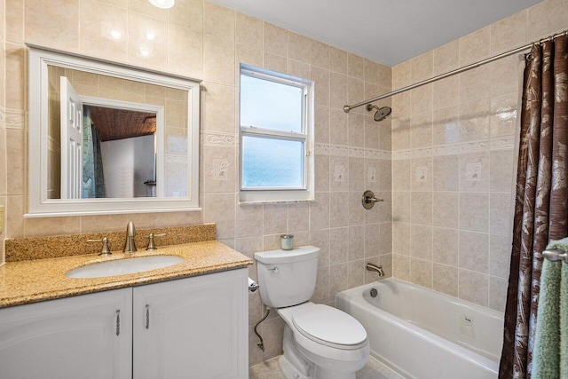 full bathroom with toilet, shower / bath combination with curtain, vanity, and tile walls