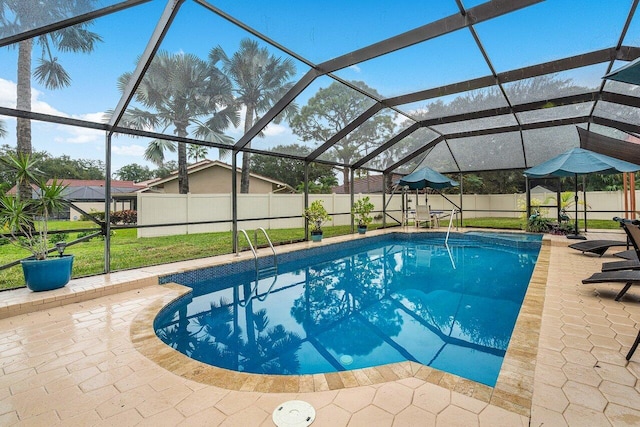 view of swimming pool featuring glass enclosure, a lawn, and a patio