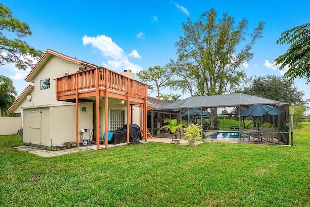 rear view of house featuring a lanai, a swimming pool side deck, and a lawn