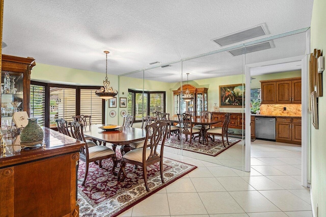 dining space with a textured ceiling and light tile patterned floors