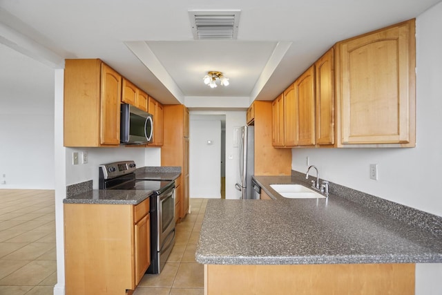 kitchen featuring sink, light tile patterned floors, stainless steel appliances, and a tray ceiling