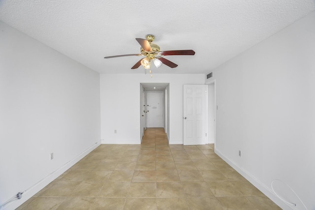 tiled empty room with a textured ceiling and ceiling fan