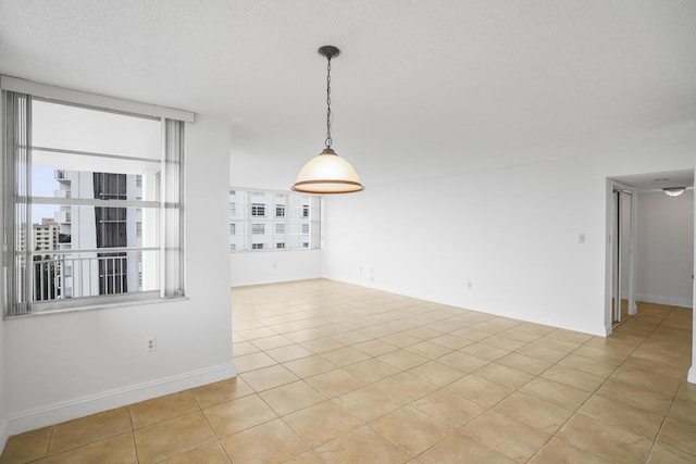 spare room with light tile patterned floors and a textured ceiling