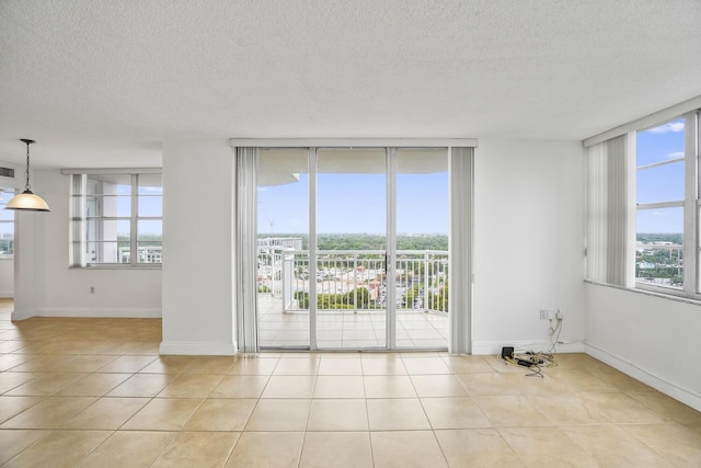 spare room featuring light tile patterned flooring and a textured ceiling