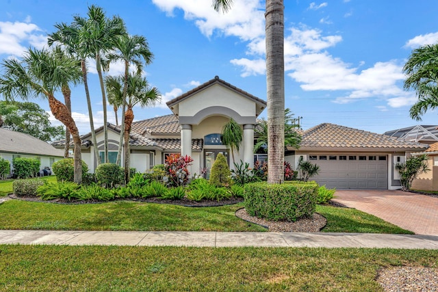 mediterranean / spanish house featuring a garage and a front yard