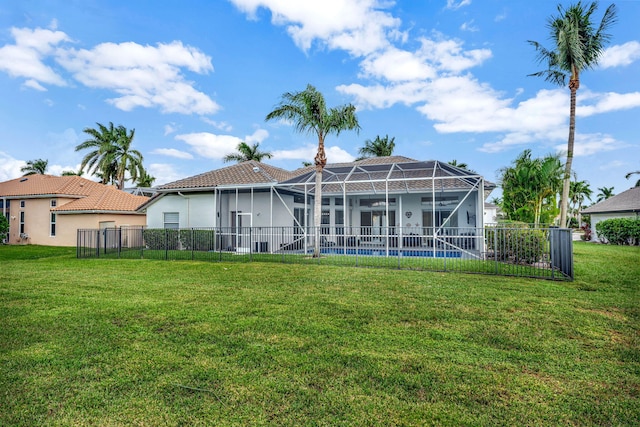 back of house with a lanai, a pool, and a lawn