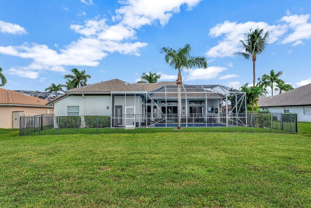 rear view of house with glass enclosure, a yard, and a swimming pool