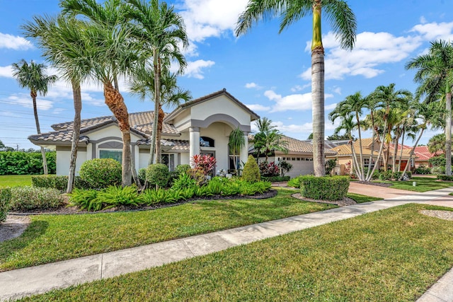 mediterranean / spanish-style house with a garage and a front lawn