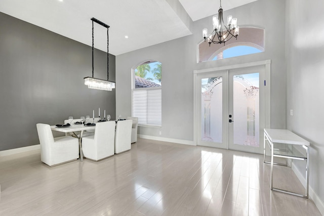 interior space with a chandelier, light hardwood / wood-style floors, and french doors