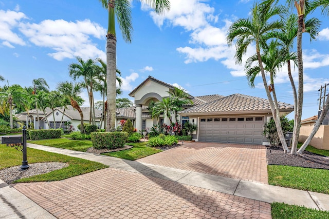 mediterranean / spanish house featuring a front yard and a garage