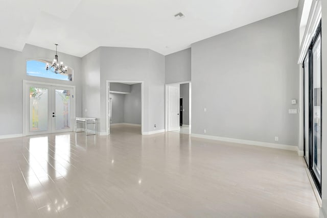 entryway with a high ceiling, a chandelier, and french doors