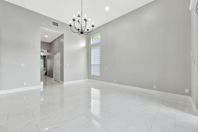 empty room featuring plenty of natural light and a chandelier