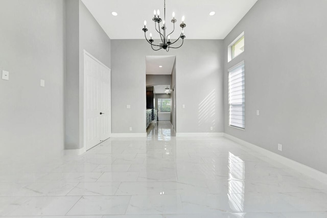 unfurnished room with an inviting chandelier