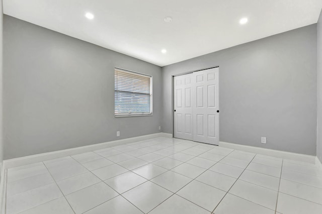 unfurnished bedroom with a closet and light tile patterned flooring