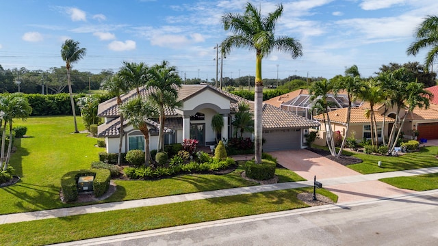 mediterranean / spanish-style home featuring a front lawn and a garage