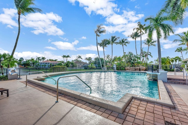 view of swimming pool featuring pool water feature and a patio