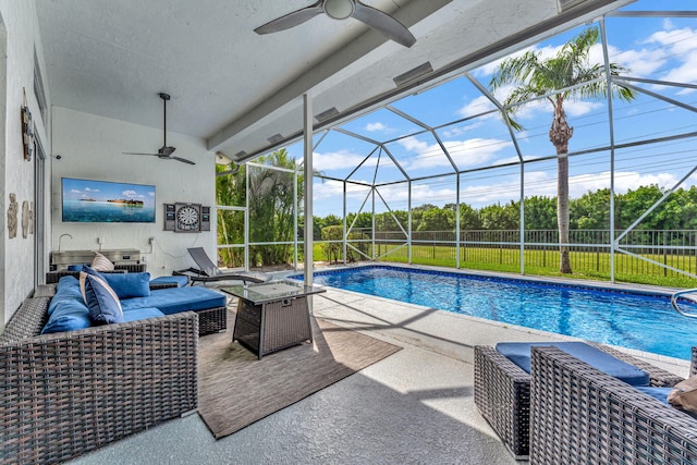 view of swimming pool featuring glass enclosure, a patio area, ceiling fan, and an outdoor hangout area