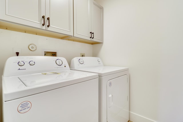 washroom with cabinets and washing machine and clothes dryer