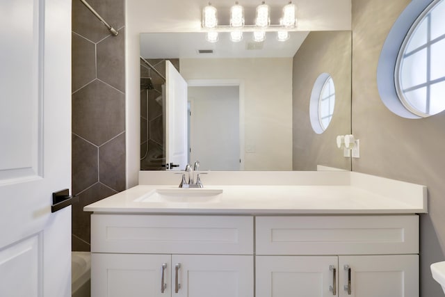 bathroom with vanity and a tile shower