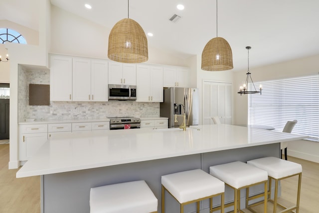 kitchen featuring a kitchen breakfast bar, stainless steel appliances, decorative backsplash, and a large island